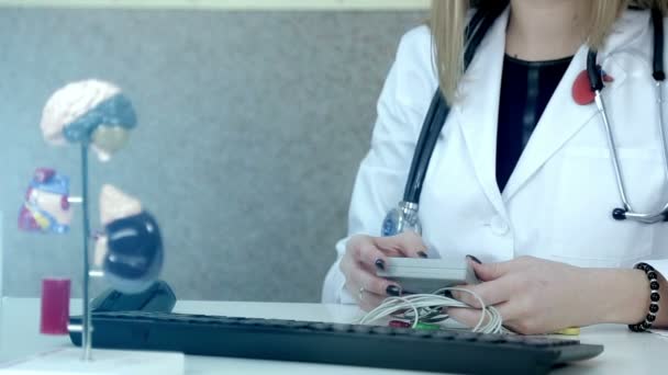 Доктор кардиолог, приносит информацию на компьютер с держателем — стоковое видео