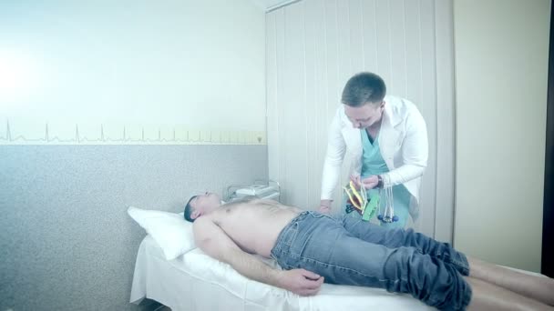 Lékaři ruce připojení elektrod pro EKG — Stock video