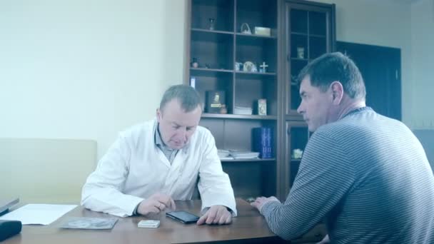 Doctor using a mobile phone and a tablet. A male doctor using electronic devices. — Stock Video