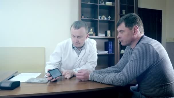 Доктор демонстрирует кардиограмму на мобильном телефоне — стоковое видео
