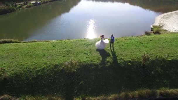 Baile de boda. el día de la boda. Los recién casados están bailando en el paseo marítimo. novia y novio bailan cerca del pintoresco lago azul — Vídeos de Stock