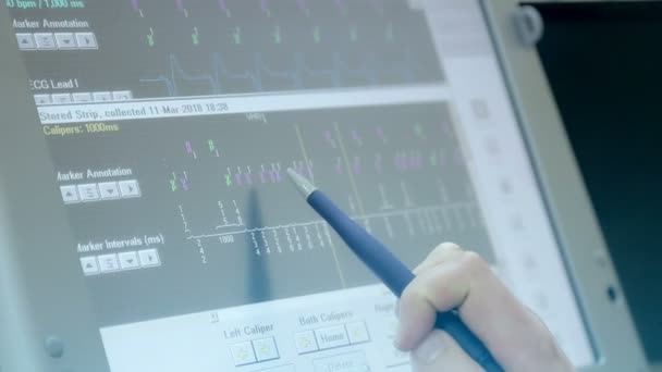 Крупным планом врач стилус проводит компьютерный экран, исследуя сердце пациента — стоковое видео