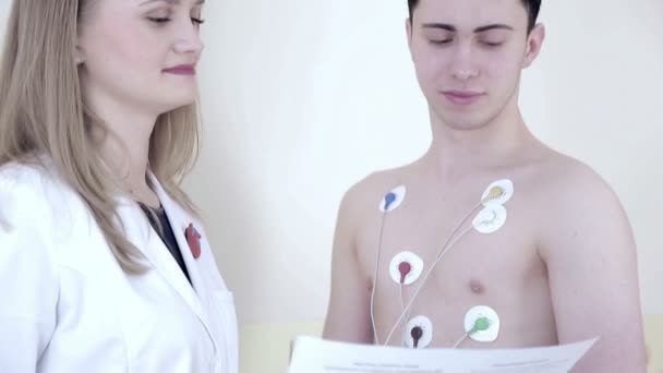 Instalación de sensores en el paciente para examen cardíaco. Monitor HOLTER. Este aparato monitorea la actividad cardíaca durante el período — Vídeos de Stock