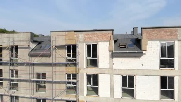 Luchtzicht Vlucht over de onafgewerkte gevel van een gebouw met meerdere verdiepingen. Bouw van een gebouw met meerdere verdiepingen. — Stockvideo