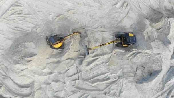 Luchtfoto, twee graafmachines werken in een zandbak. Extractie van zand. Werk van twee gele graafmachines Uitzicht vanaf de bovenkant — Stockvideo