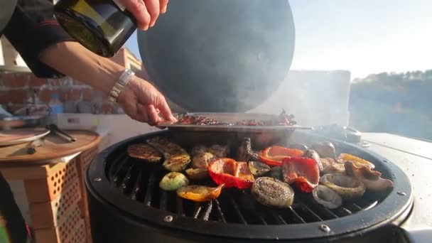 Kawałki mięsa, kurczaka, żeberka, smażone na ogniu. Szefowie kuchni przewracają ręce przez mięso. Gotowanie mięsa Bbq na dachu domu, przed piękną panoramą. — Wideo stockowe