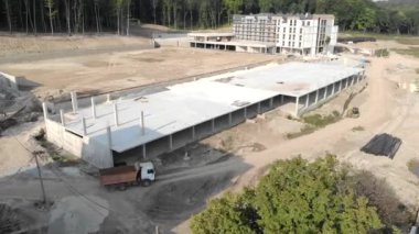 İnşaat halindeki bir tuğla evin üzerinde uçuyordu. İnşaat işçileri tuğladan bir ev inşa ediyorlar. Yeni ev hava görüntüsü
