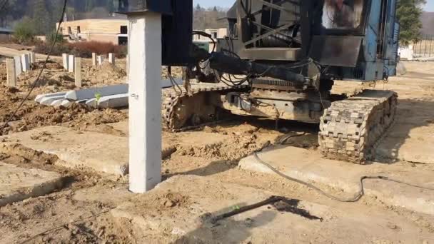 A gép belerohan a földbe, és építkezik. Megerősített betonszerkezetek alapításának építése. — Stock videók