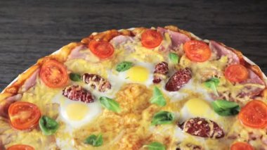 Peynirli domatesli yakın plan pizza, sosis ve yumurta, kendi etrafında dönüyor, yukarıdan manzara
