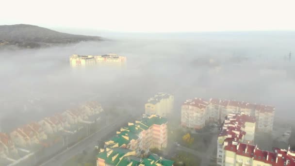 Flygfoto över husen som är täckta av morgondimma. Flyg över staden Lviv i Ukraina. Fantastisk morgon i dimman filmad av drönare — Stockvideo