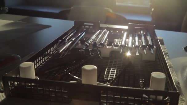 The dentists tool kit is in a special box in the sunlight. The sun is reflected on the edge of the dental instrument — ストック動画