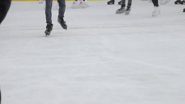 Touristen skaten aus nächster Nähe auf einer großen Eisbahn. Füße nach dem Schlittschuhlaufen auf einem zugefrorenen See. — Stockvideo