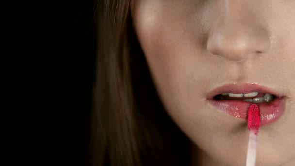 Hände der Make-up-Künstlerin, die die Lippen der Mädchen aus nächster Nähe zeichnet. Knochen bemalt ihre Lippen mit rotem Lippenstift. Model arbeitet in der Modebranche — Stockvideo