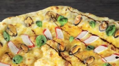 En üstten siyah arkaplan manzaralı yengeç çubuklu pizza.