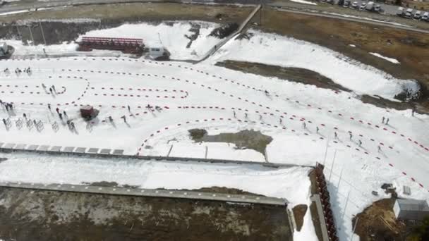 Uitzicht vanaf de top van een groep biatlonskiërs die de afstand overbruggen. Een groep skiërs, het uitzicht vanaf de drone — Stockvideo