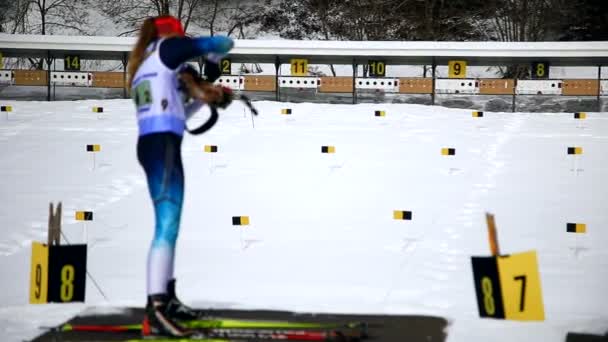 Ukraina. Det är Yavoriv. 04 januari 2020. En skidåkare som deltar i skidskytte loppet, skjuter ett gevär mot ett mål. — Stockvideo