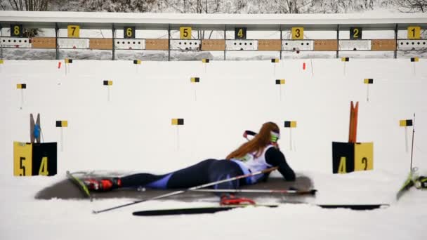 Ukraine. Yavoriv. 04 January 2020. Skier who takes part in the biathlon race, shoots a rifle at a target lying down — Stock Video