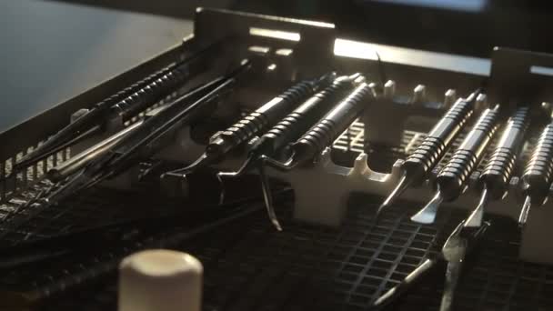 The dentists tool kit is in a special box in the sunlight. The sun is reflected on the edge of the dental instrument — Stock Video