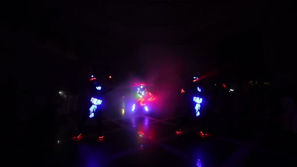 Lasershow. In einem dunklen Raum führen Künstler Tanz und Lasershow vor. Kleidung leuchtet mit Eis und Laserlicht. Nächtliche Laserdisco. — Stockvideo