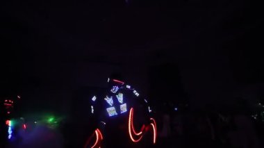Lazer şovu. Sanatçılar karanlık bir odada dans ve lazer gösterisi yapar. Giysiler buz ve lazer ışığıyla parlıyor. Gece lazer diskosu.