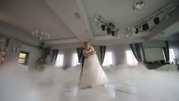 Танець наречених на весіллі. Важкий дим, який виділяється білим світлом. Перший танець молодят на весіллі . — стокове відео