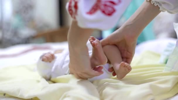 The mother holds the legs of a small child in her hands. The mother and child. — Stock Video