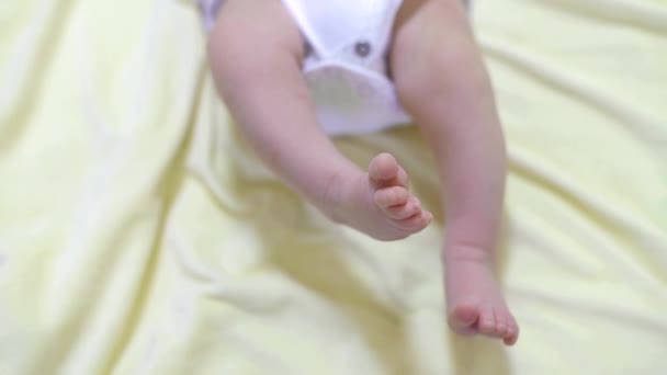 Nohy malého dítěte. Dítě při ležení škubne nohama.. — Stock video