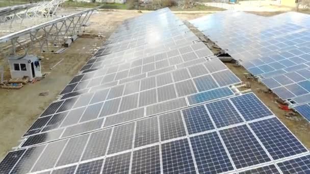 Aérea Volando sobre una planta de energía del panel solar. Los trabajadores instalan paneles solares y alimentarán la planta — Vídeo de stock