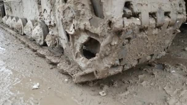 Excavator wheels close up on a swamp. Slow motion of crawler wheels of large machinery — Stock Video