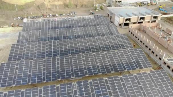 Vista aérea en círculo de la construcción de una planta de energía solar y la instalación de paneles solares. Construcción de una central de energía alternativa . — Vídeos de Stock