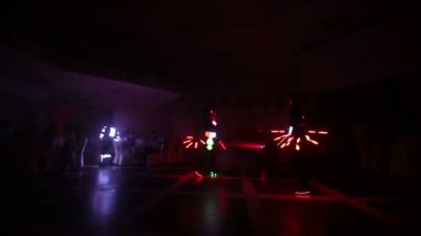 Lazer şovu. Sanatçılar karanlık bir odada dans ve lazer gösterisi yapar. Giysiler buz ve lazer ışığıyla parlıyor. Gece lazer diskosu.