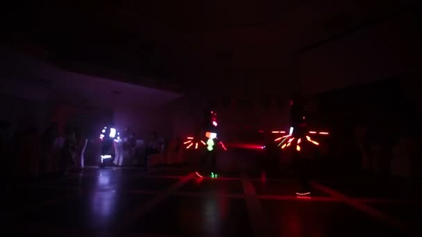 Spectacle au laser. Des artistes présentent des spectacles de danse et de laser dans une pièce sombre. Les vêtements brillent de glace et de lumière laser. Discothèque laser de nuit. — Video
