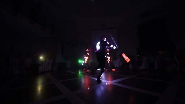 Lazer şovu. Sanatçılar karanlık bir odada dans ve lazer gösterisi yapar. Giysiler buz ve lazer ışığıyla parlıyor. Gece lazer diskosu. — Stok video