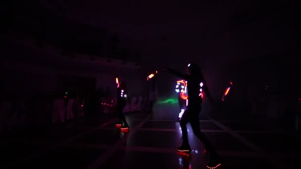 Lasergeleide show. Kunstenaars demonstreren dans en lasershow in een donkere kamer. Kleding gloeit met ijs en laserlicht. Nachtlaser disco. — Stockvideo
