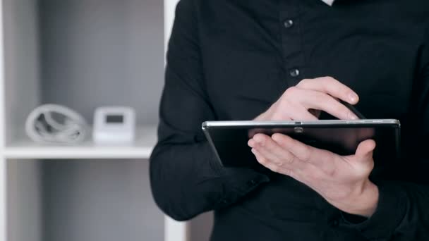 Close-up van een zakenman hand houdt een stylus in zijn hand en werkt aan een tablet — Stockvideo