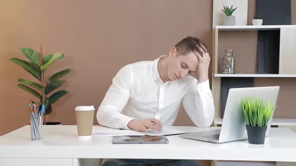 Stress op de werkplek op kantoor. Een zakenman die achter een computer werkt is moe van het werken.. — Stockvideo