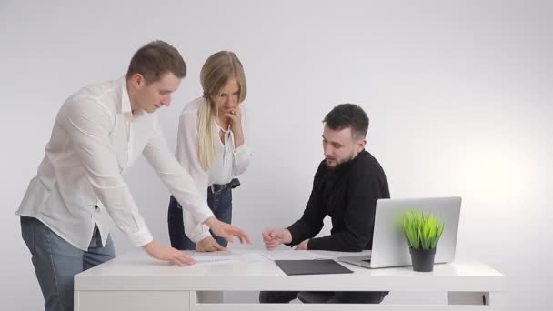 Two businessmen together with the boss in the office discuss the business partnership with the help of papers and look at the comupter together. — Stock Video