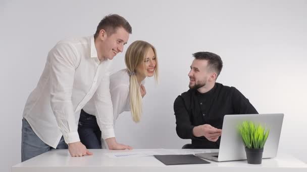 Οι επιχειρηματικοί συνεργάτες, μαζί με το διευθυντή τους, βλέπουν πληροφορίες στον υπολογιστή και χαμογελούν. Ευτυχισμένοι εργαζόμενοι στο γραφείο στον υπολογιστή — Αρχείο Βίντεο