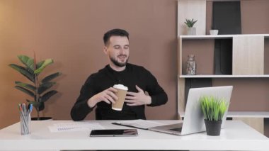 İş adamı işyerinde kahve içiyor. Ofis çalışanı bilgisayarda çalışıyor, kahve içiyor..