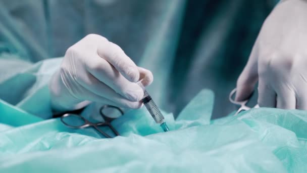 O médico cirurgião administra uma injeção durante a operação. Anestesia local no local da incisão . — Vídeo de Stock
