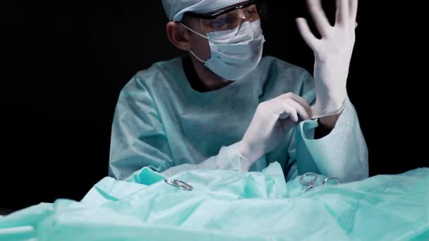 Cirujano se pone guantes estériles en las manos durante la cirugía y se prepara para la cirugía . — Vídeos de Stock