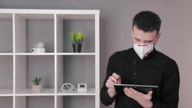 Koruyucu tıbbi maskeli doktor ofisindeki tablette çalışıyor..