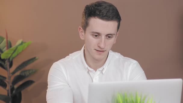 एक सफेद शर्ट में एक व्यापारी की भावनाएं जो कार्यालय में कंप्यूटर पर काम करती हैं . — स्टॉक वीडियो