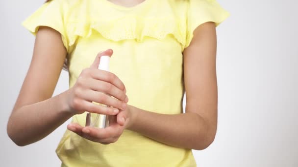 小孩用防腐剂处理他们的手.一个小女孩在手上喷了些消毒剂溶液，并用消毒剂处理她的双手. — 图库视频影像