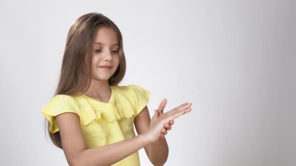 Μικρό παιδί αντιμετωπίζει τα χέρια τους με αντισηπτικό. Ένα μικρό κορίτσι ψεκάζει ένα διάλυμα αντισηπτικού στα χέρια της και περιποιείται τα χέρια της με αντισηπτικό. — Αρχείο Βίντεο