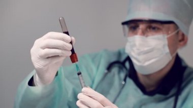 Laboratuvardaki doktor kan tahlili için test tüpünden şırıngaya kan alıyor. Covid19 Coronavirus için kan testi