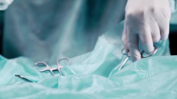 Docteur effectue une opération de gros plan. Le médecin tient des pinces à épiler avec des pinces et traite l'incision . — Video