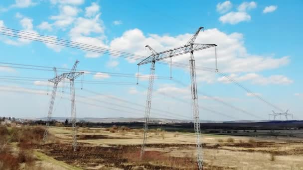 Vista aérea Linhas de transmissão de energia de longa distância. Pólos de alta tensão que transmitem eficientemente milhares de quilovolts de eletricidade entre cidades — Vídeo de Stock