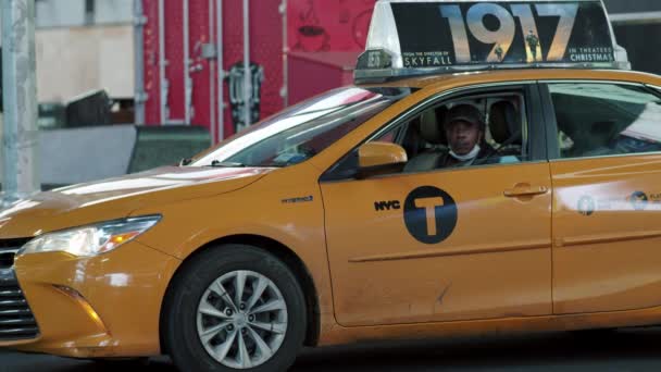 New York City, USA - 14 april 2020 En taxichaufför sitter i en bil på Time Square på natten under epidemin Covid19 — Stockvideo