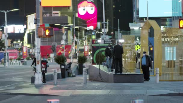 Нью-Йорк, США - 14 апреля 2020 года Операторы и журналисты в защитных масках ночью на Таймс-сквер во время пандемии ковида-19 — стоковое видео